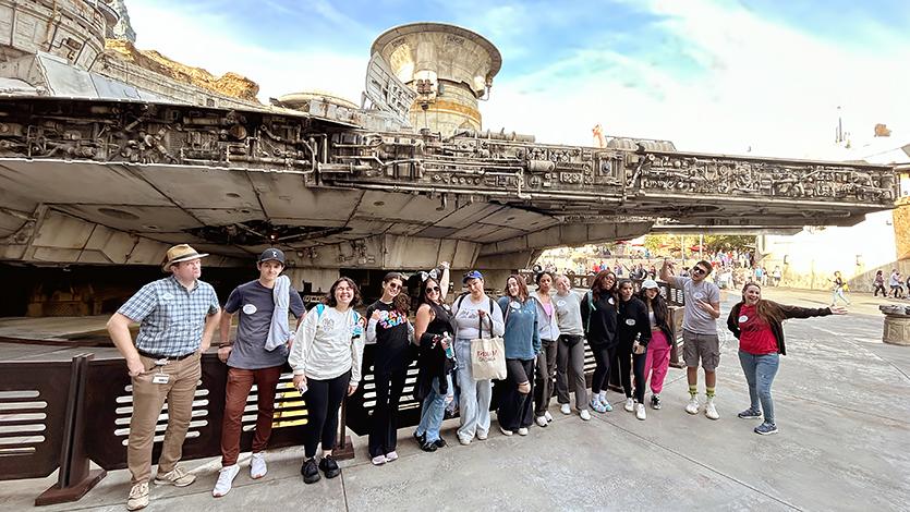 Image of the class standing in front of the Millennium Falcon from Star Wars. 